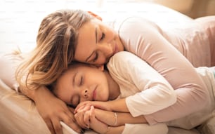 Lei dorme in abbraccio materno. Madre e figlia che dormono.
