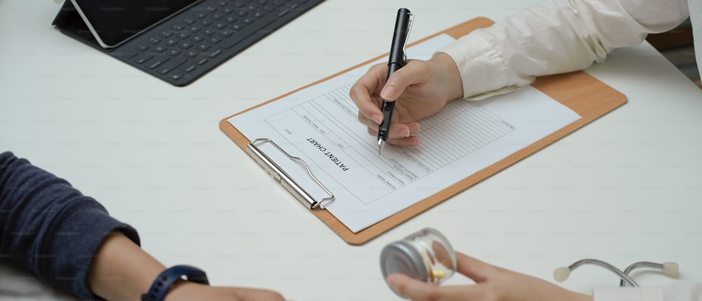 Cropped shot of doctor giving pills to patient while looking information on medical record