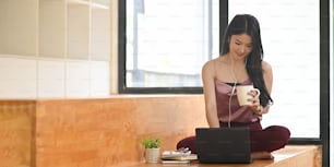 Asian woman relaxation with laptop her listening the music and sitting in living room.