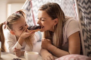 Sweet breakfast. Mother and daughter having breakfast in bed.