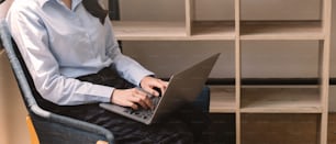 Ausschnittaufnahme einer Frau, die ihren Laptop zu Hause benutzt