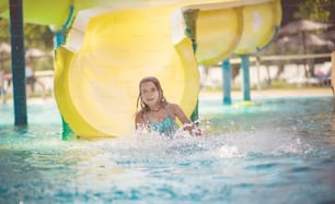 Coolest way to spend summer. Child having fun on pool toboggan.