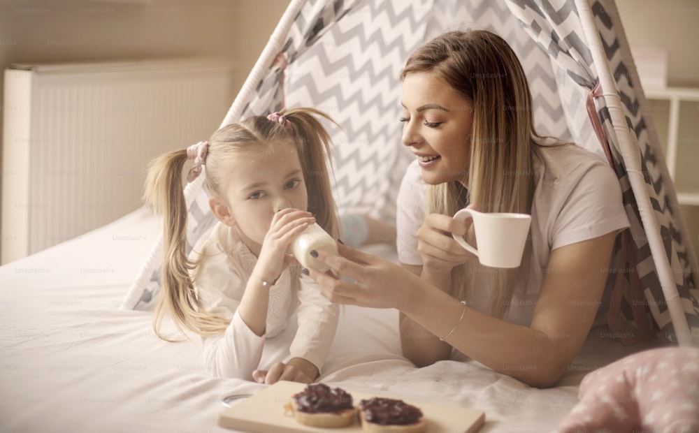 The most beautiful breakfast is in bed.  Mother and daughter having breakfast in bed.
