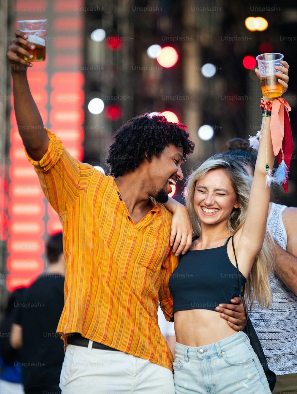 Young and cheerful couple dancing in music festival.