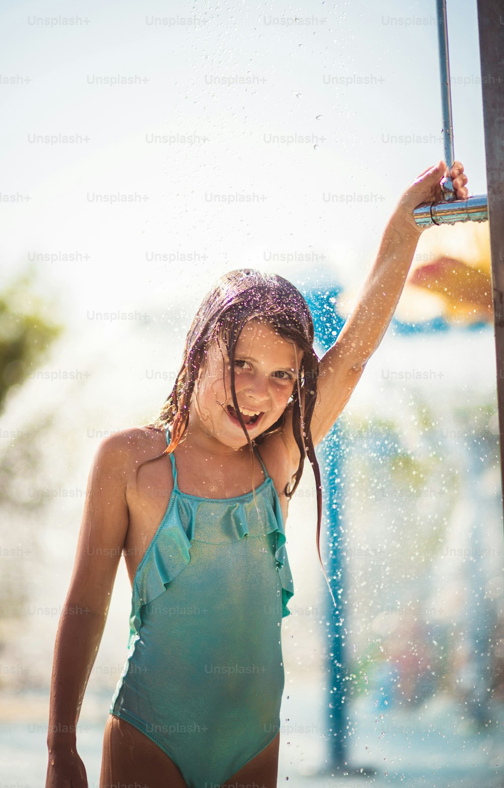 The perfect way to cool off. Child showering after pool.