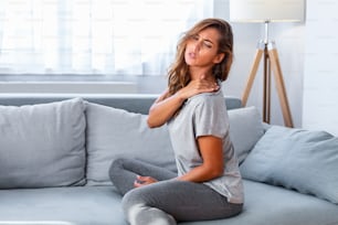 Pain in the shoulder. Upper arm pain, People with body-muscles problem, Healthcare And Medicine concept. Attractive woman sitting on the bed and holding painful shoulder with another hand.