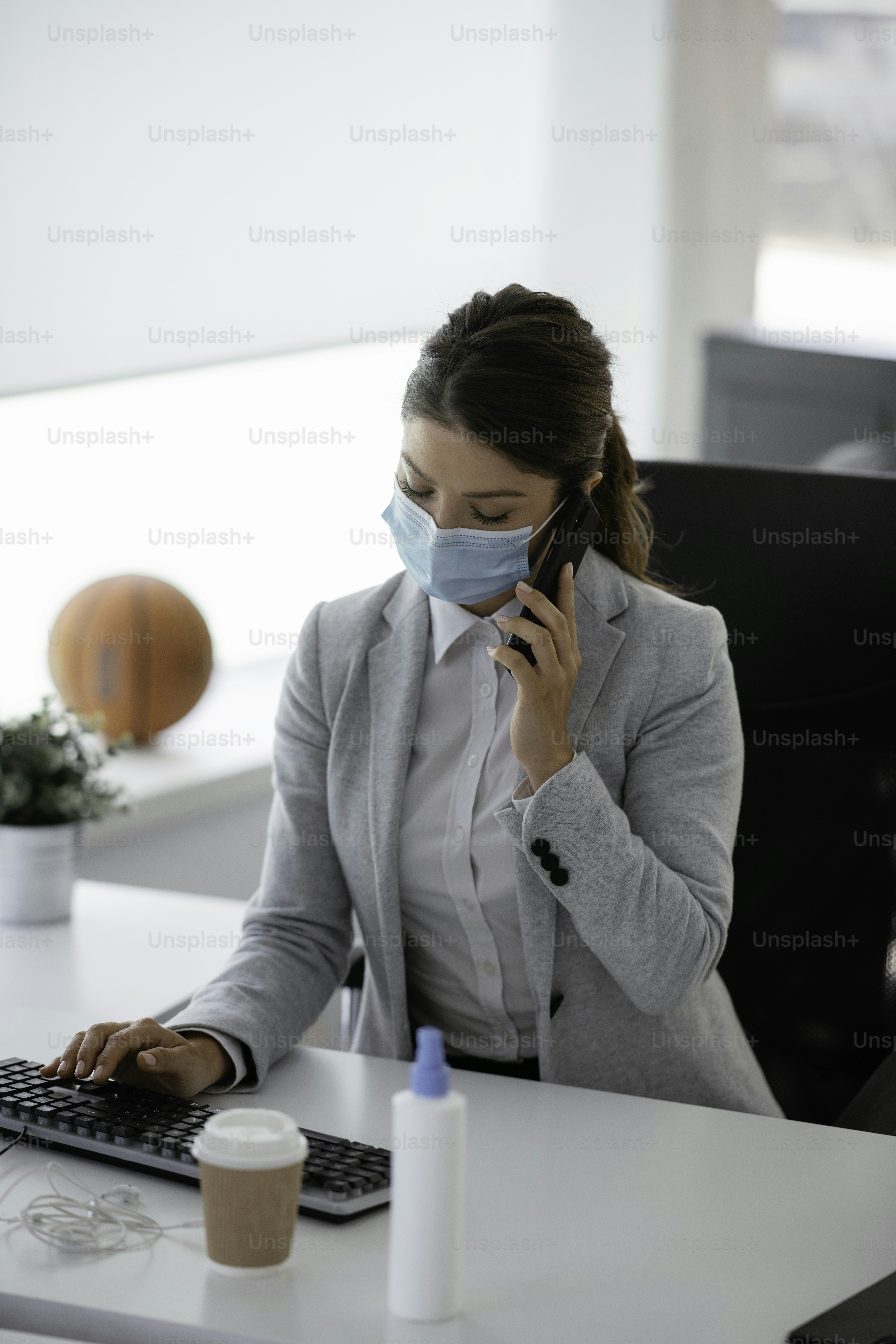 Beautiful businesswoman with medical mask working in office. Covid 19 concept.