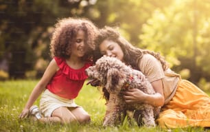 I nostri nuovi amici. Madre e figlia che giocano con il cane nel parco.