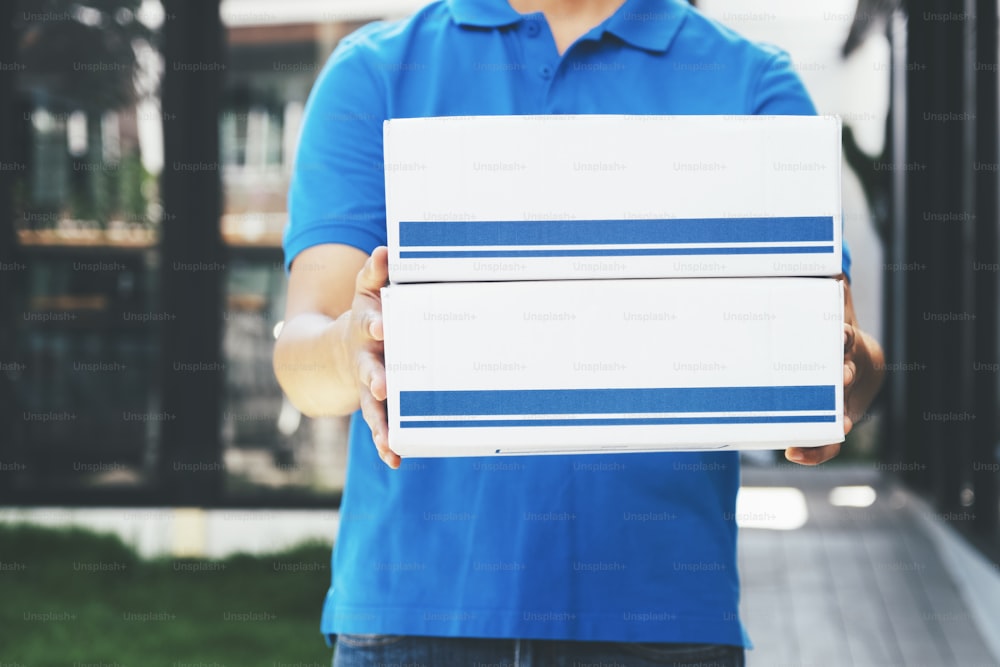 Repartidor sosteniendo cajas de cartón. Compras en línea y entrega exprés.