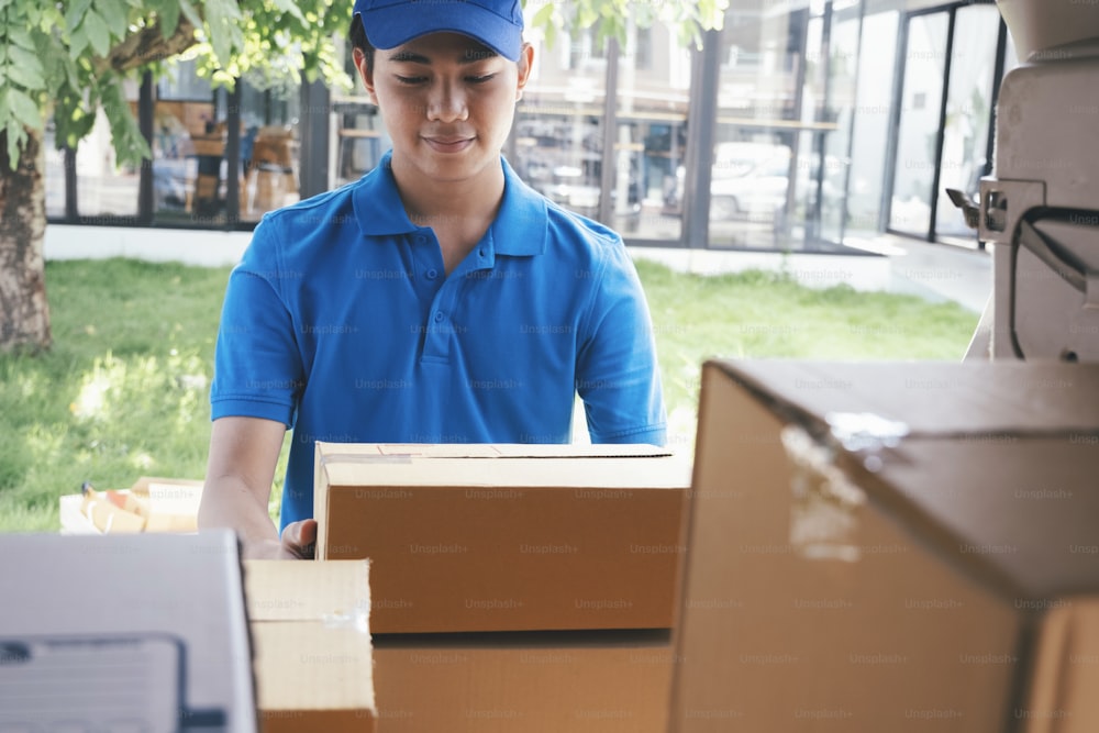 Repartidor cargando cajas de cartón en una furgoneta de reparto. Servicio de envío y entrega comercial.