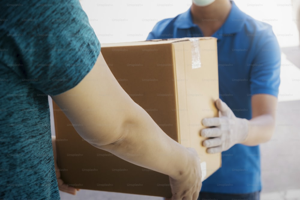 Young woman receiving parcel from delivery man.