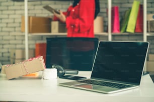 Laptop computer with empty screen on shipping box background. Concept of online retail store, delivery order and customer service.