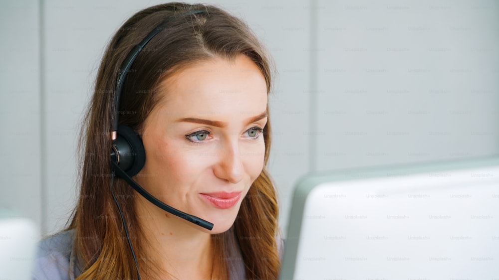 Business people wearing headset working in office to support remote customer or colleague. Call center, telemarketing, customer support agent provide service on telephone video conference call.