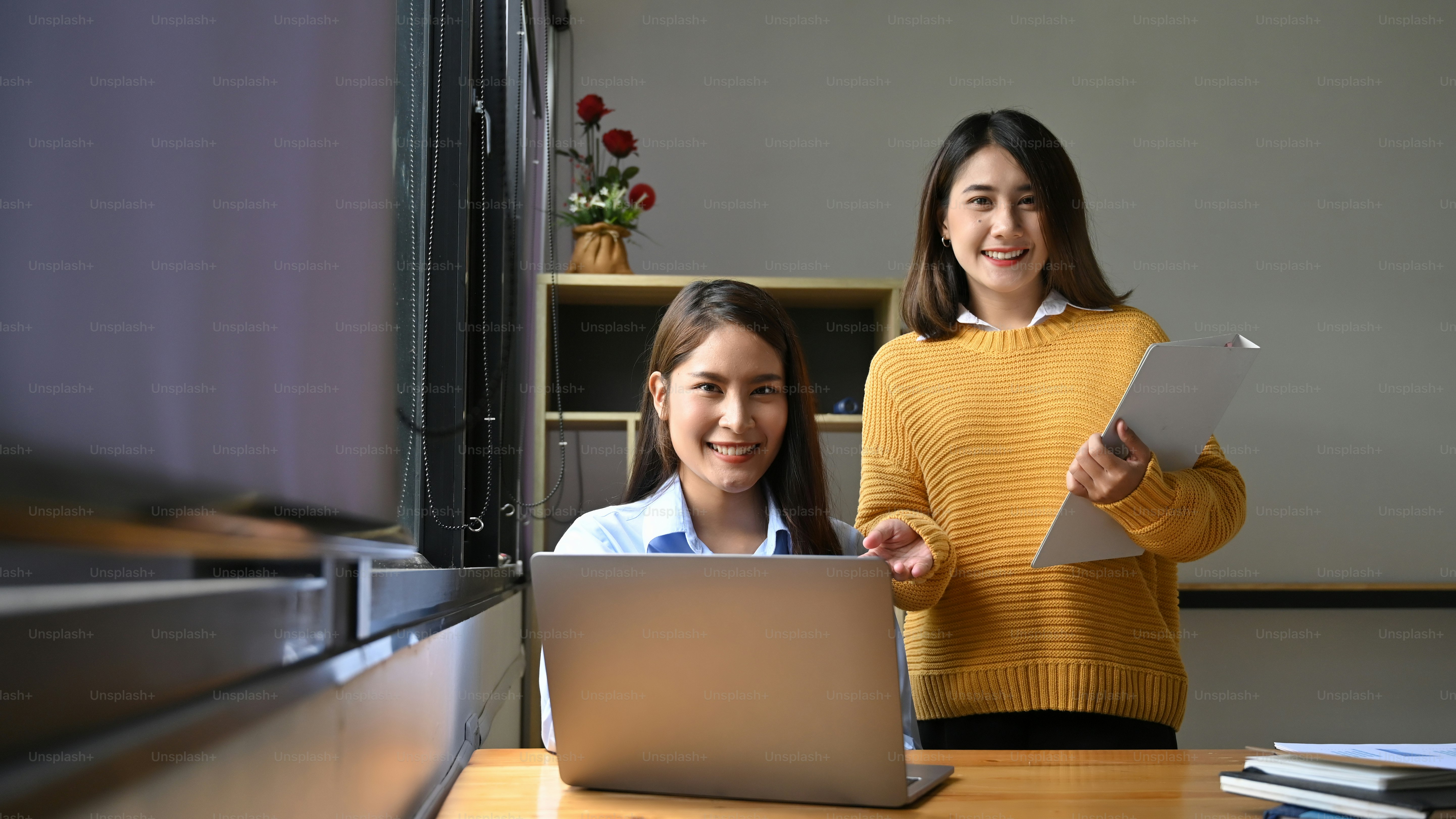 A young secretary is sending a document file to her colleague while ...