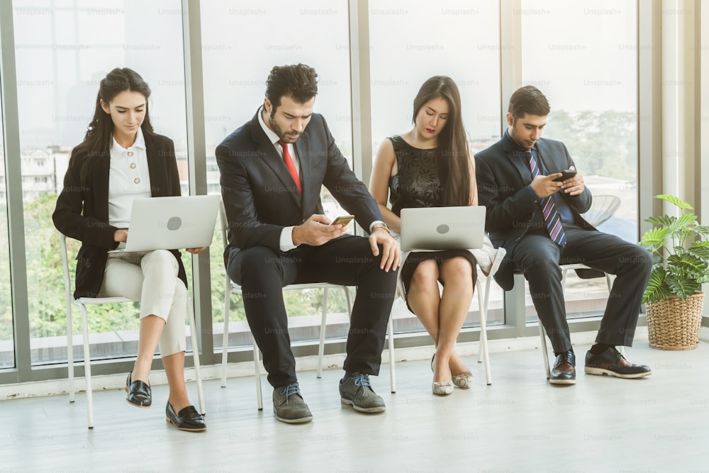 Job seekers and applicants waiting for interview on chairs in office. Job application and recruitment interview qualification concept.