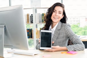 Empty tablet computer screen shown by woman in office for product , website and mobile app presentation.