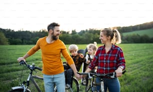 Family with two small children on cycling trip in nature, resting.