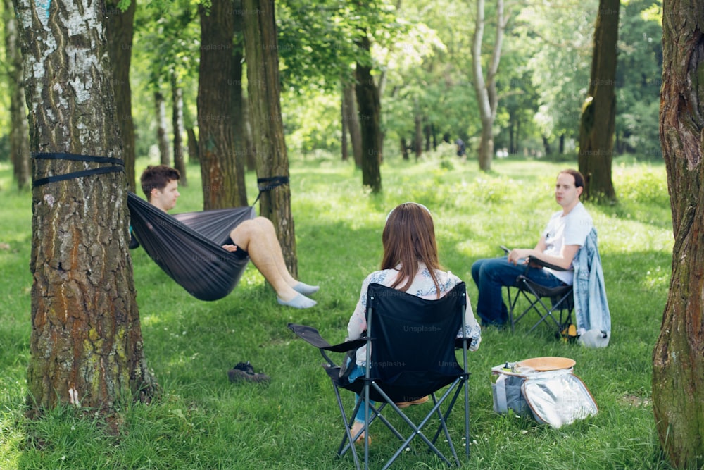 Social distancing. Small group of people enjoying picnic time in accordance with social distancing in summer park. Safety gatherings in new world.