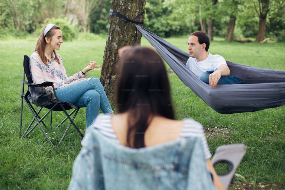 ソーシャルディスタンシング。夏の公園でソーシャルディスタンスを保ったピクニックで会話を楽しむ少人数のグループ。ニューノーマルでのレジャー活動、安全プロトコルに従った集まり
