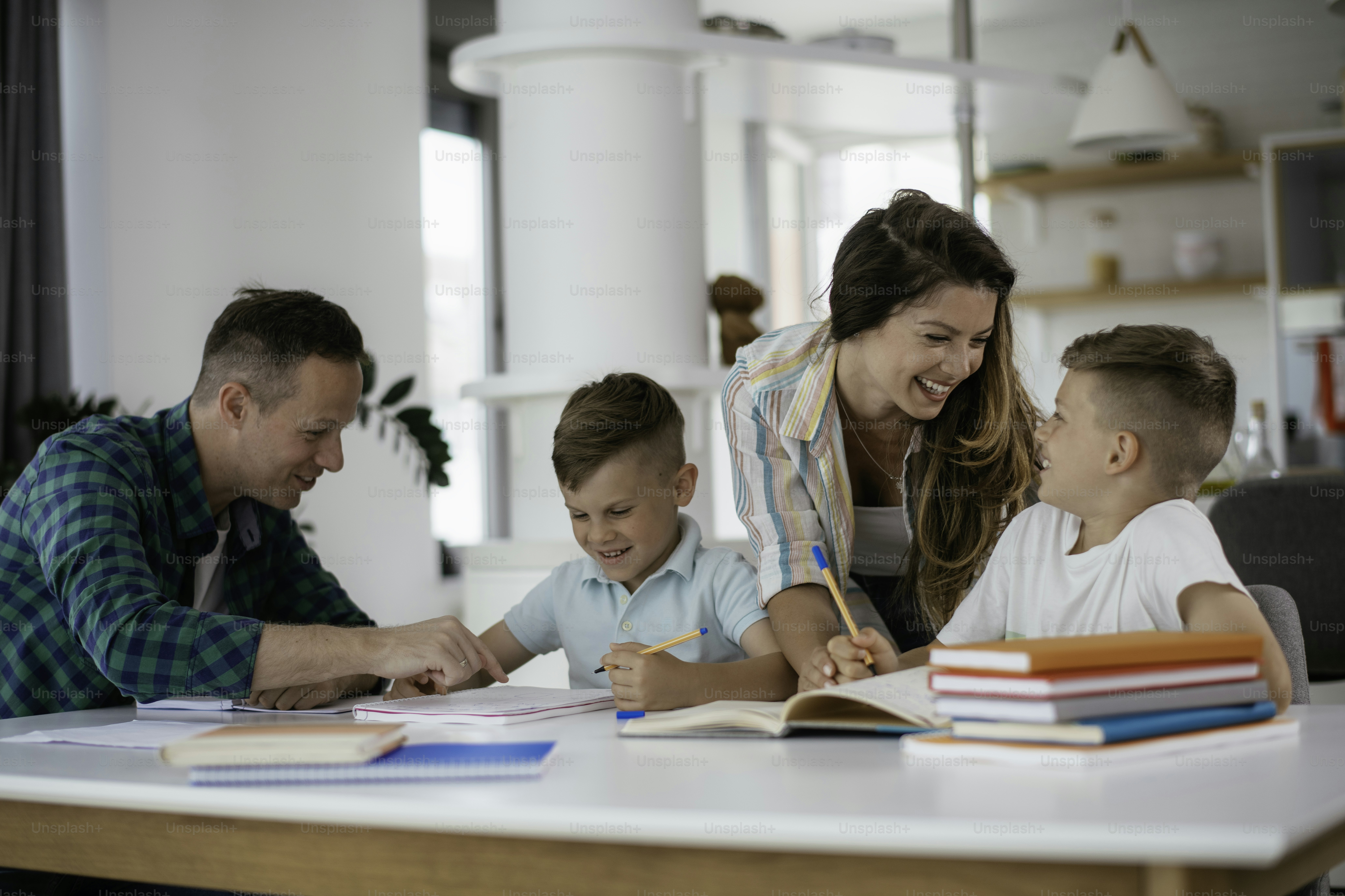 Padres ayudando a los niños con sus tareas. Pequeños niños aprendiendo ...