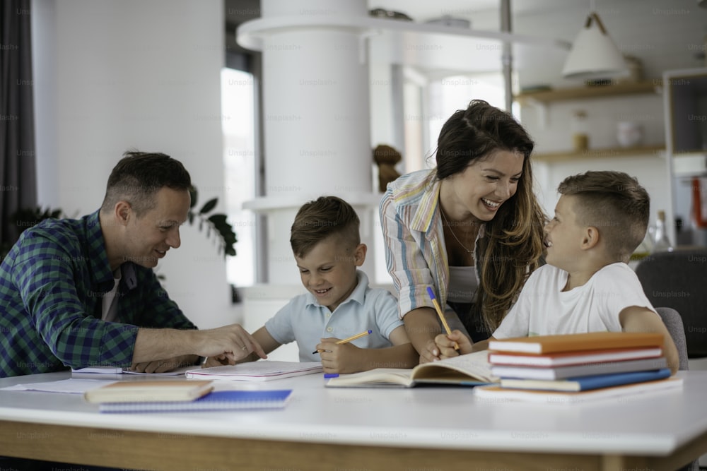 Parents helping the kids with their homework. Litlle boys learning at home.