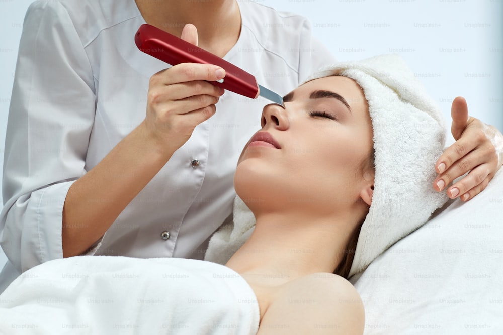 face of beautiful woman while procedure ultrasonic cleansing, facial peeling. treatment for skin rejuvenation