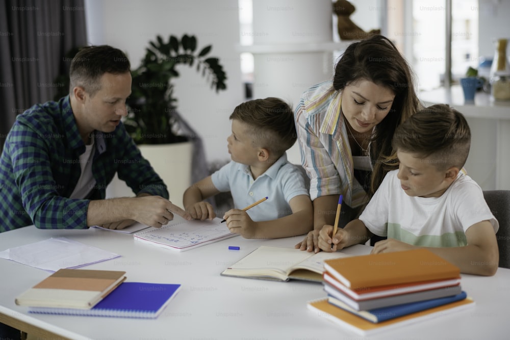 子供たちの宿題を手伝う親。自宅で学ぶLitlleの男の子。