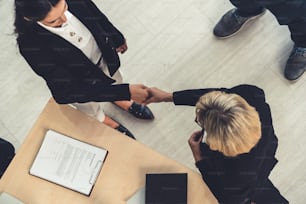 Des gens d’affaires se serrent la main dans un bureau d’entreprise montrant un accord professionnel sur un contrat d’accord financier.