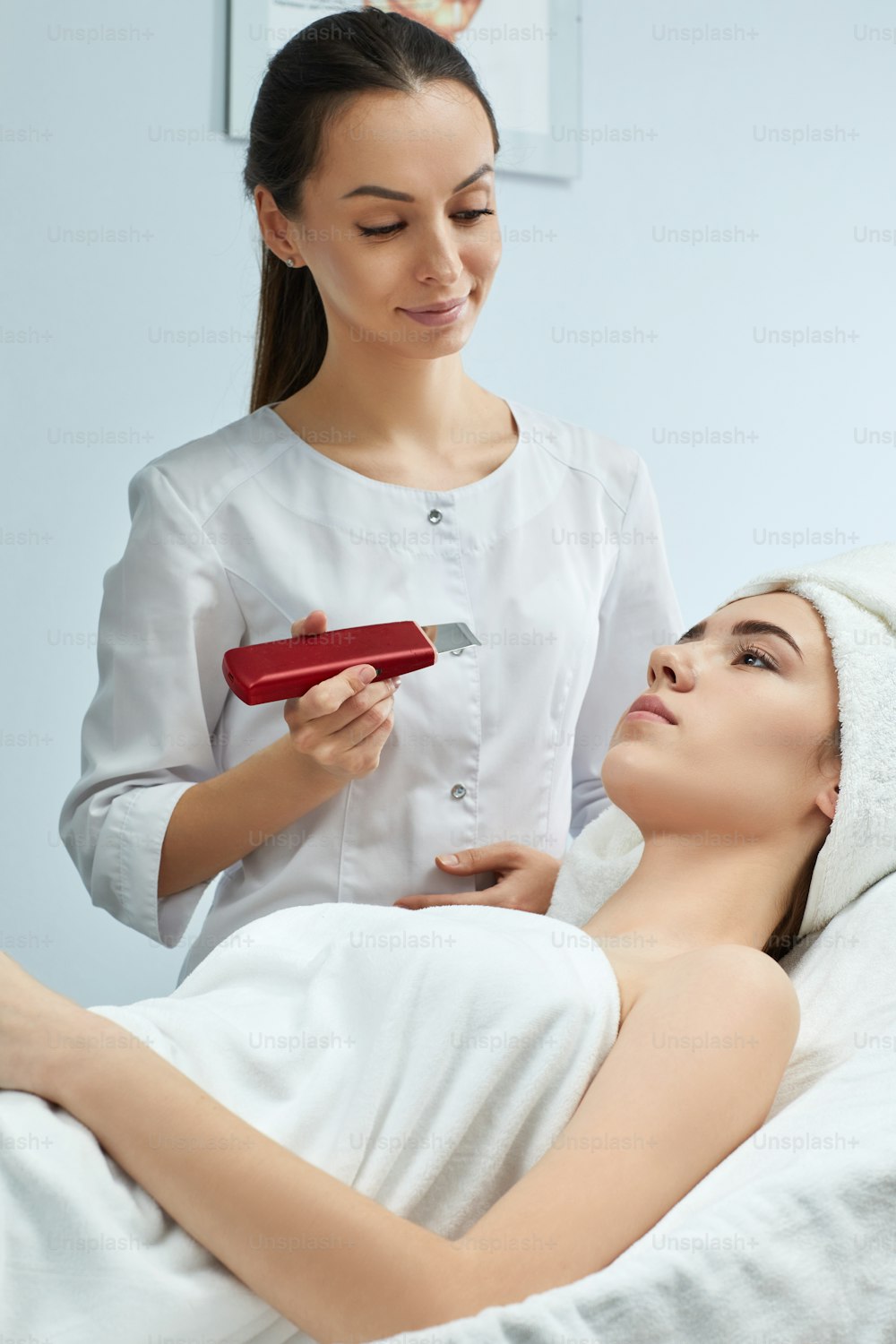 female face while procedure ultrasound cleansing. ultrasonic treatment for skin rejuvenation