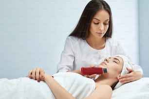 Procedura di pulizia ad ultrasuoni del viso della donna, peeling facciale. Trattamento ad ultrasuoni