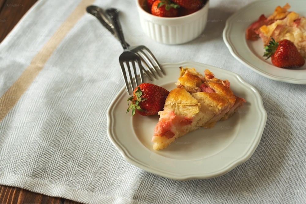 Piece of fresh strawberry and rhubarb pie on plate. Summer food eating