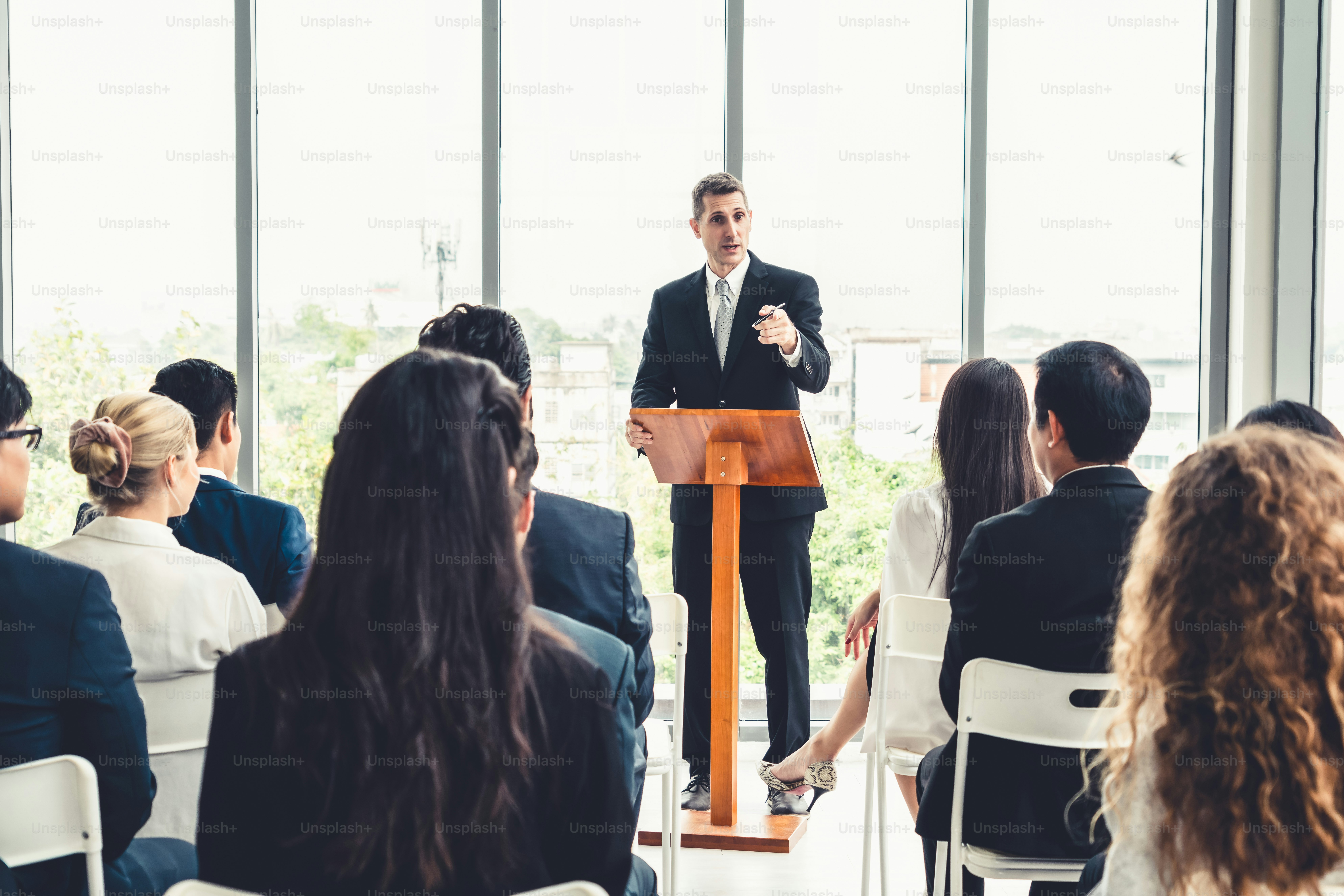 Grupo de empresarios reunidos en un seminario de conferencias. Audiencia escuchando al instructor en la sesión de capacitación de educación para empleados. Foro de la cumbre de la comunidad de trabajadores de oficina con orador experto.