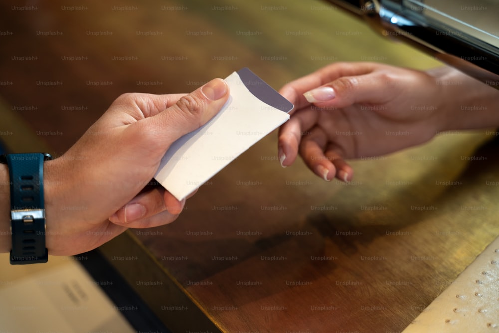 Cropped shot of a male receptionist at the counter giving keycard to a female guest