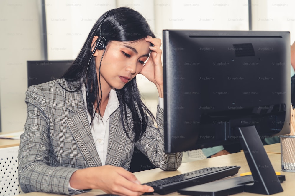 Las personas de negocios que usan auriculares se sienten infelices trabajando en la oficina. Fracaso tristeza negativa emoción concepto de centro de llamadas, telemarketing y crisis de atención al cliente en la economía financiera caída.
