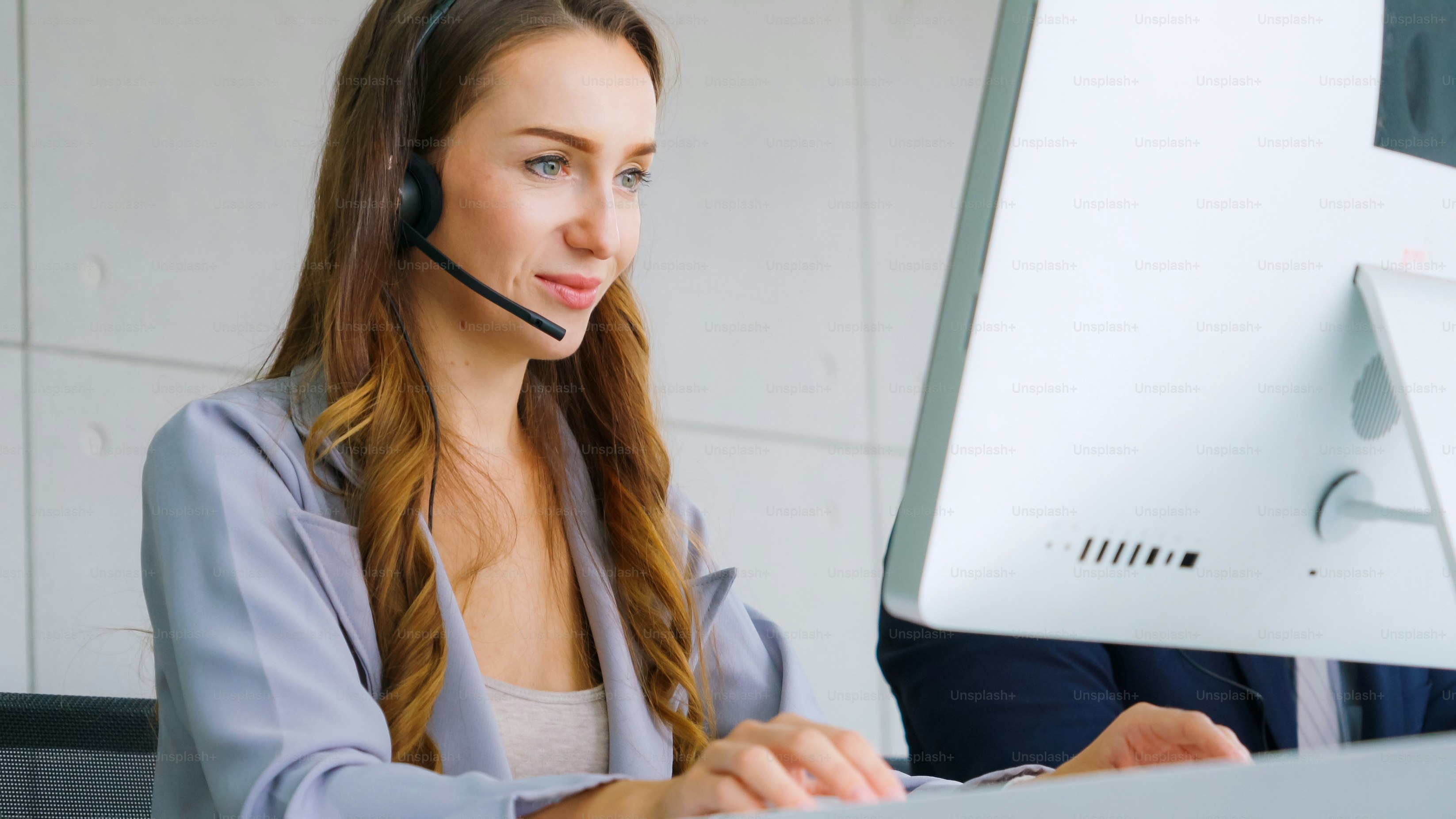 Business people wearing headset working in office to support remote customer or colleague. Call center, telemarketing, customer support agent provide service on telephone video conference call.