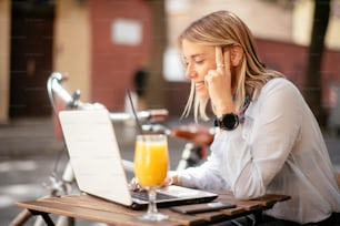 Young beautiful woman in cafe working on computer. Beautiful businesswoman working outdoors.