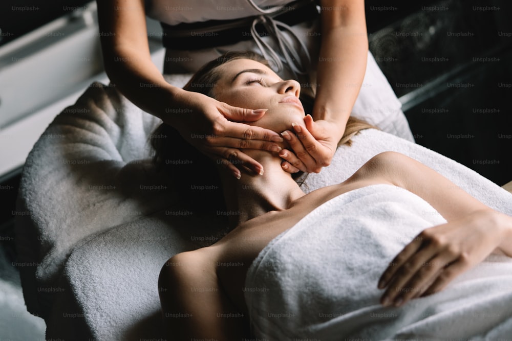 Relaxing woman having massage therapy at spa salon