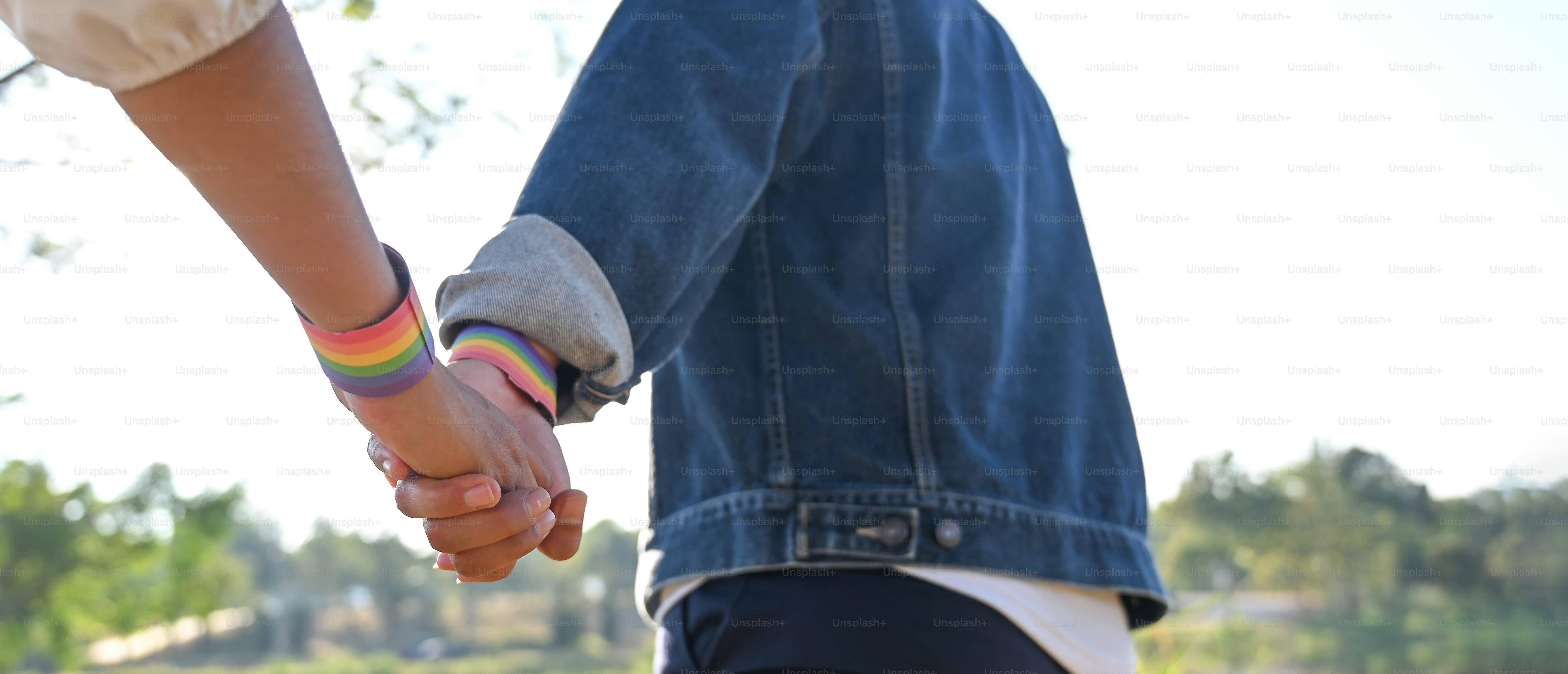The cropped image of the LGBT couple is relaxing together at the nature park.