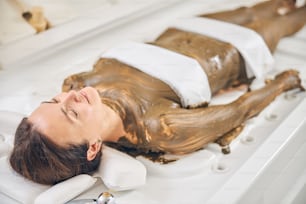 Peaceful woman relaxing with closed eyes while undergoing pleasant skin treatment procedure in spa capsule