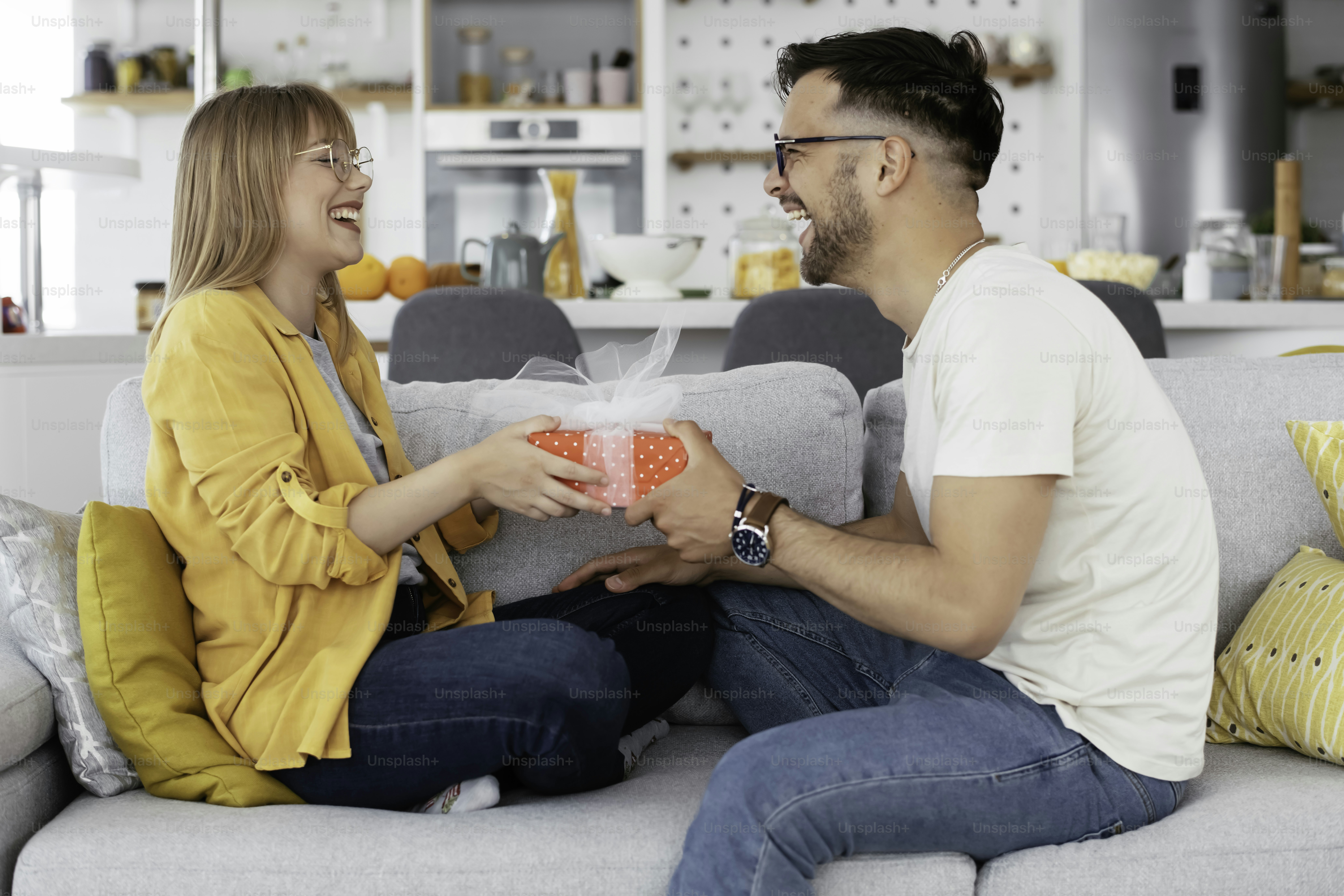 Marido surpreendendo sua esposa com um presente. Jovem dando uma caixa de presente para sua esposa.