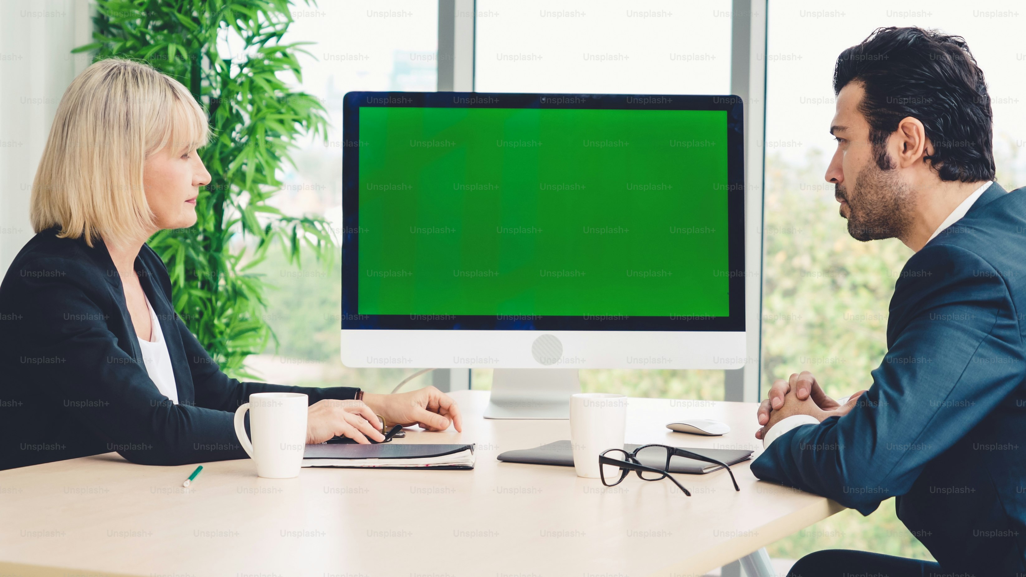 Business people in the conference room with green screen chroma key TV or computer on the office table. Diverse group of businessman and businesswoman in meeting on video conference call .