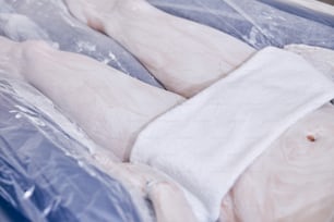 Cropped photo of a woman lying with towel on her body and having pleasant floating session