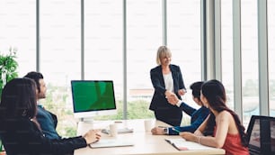 Business people in the conference room with green screen chroma key TV or computer on the office table. Diverse group of businessman and businesswoman in meeting on video conference call .