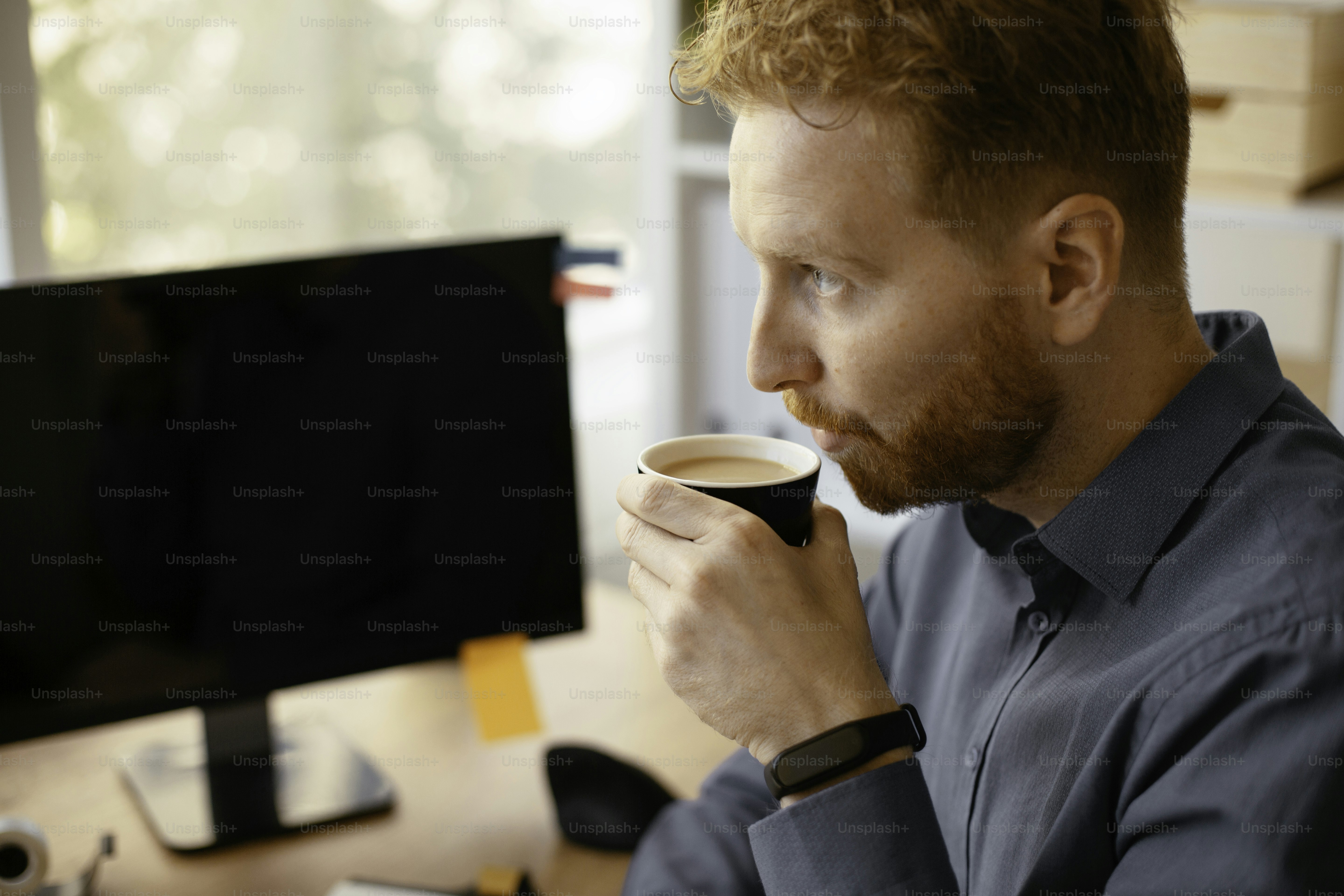 Businessman drinking coffee while working in the office.. Young man in office.