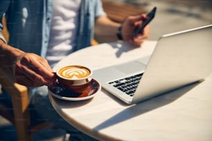 Young freelancer looking at screen of his computer while reading income message in chat