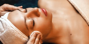 Facial massage session with a young woman lying in a professional spa salon