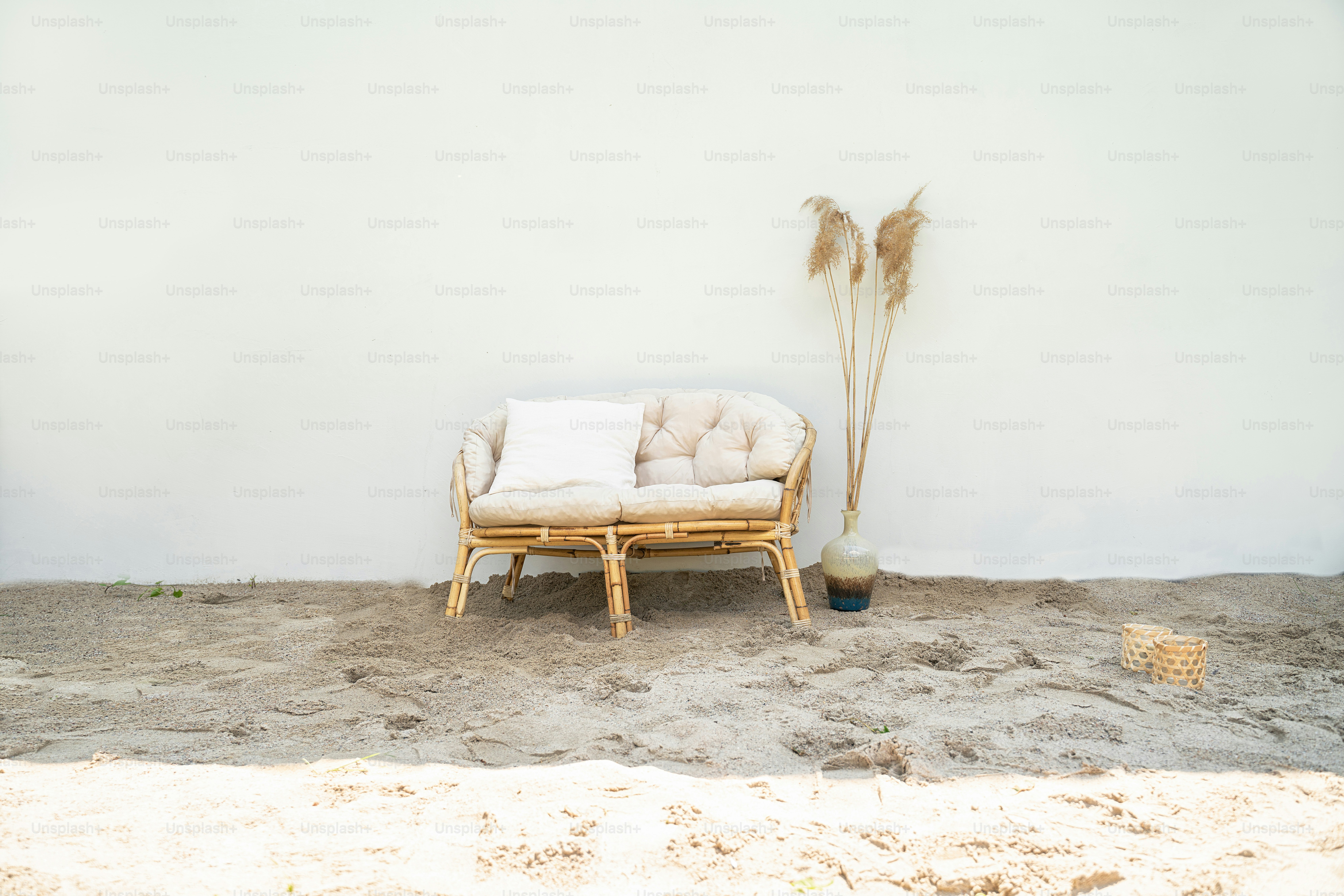 Boho eco styled beach essentials on sand by sea. Romantic picnic for couple on the beach.