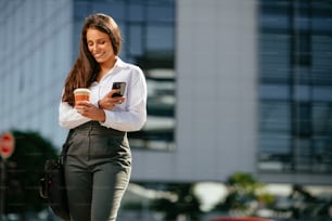 Young businesswoman drinking coffee outdoors