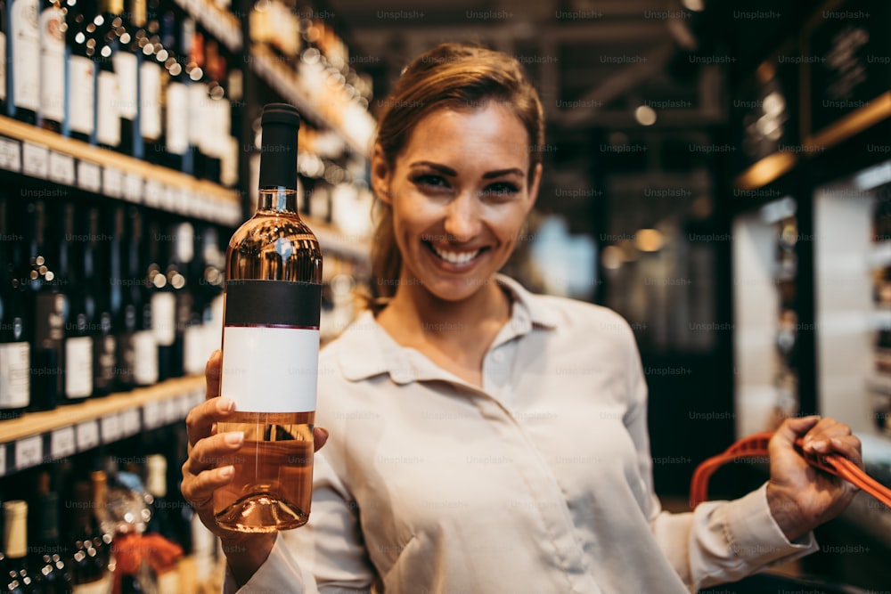 Beautiful young and elegant woman buying some healthy food and drink in modern supermarket or grocery store. Lifestyle and consumerism concept.