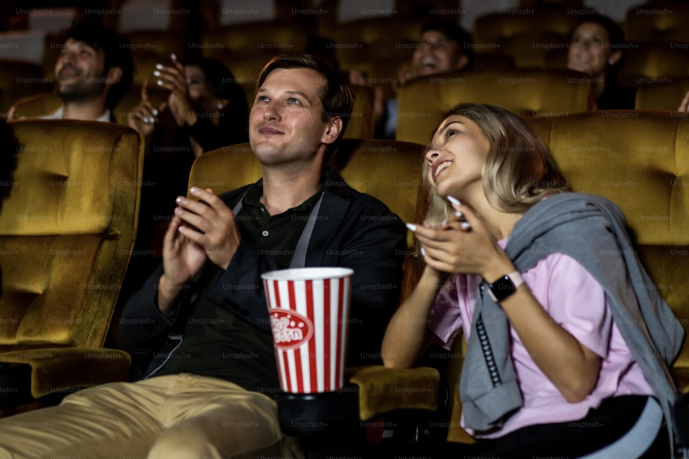 관객의 그룹은 영화관에서 행복하고 재미있는 영화를 봅니다. 그룹 레크리에이션 활동 및 엔터테인먼트 개념.
